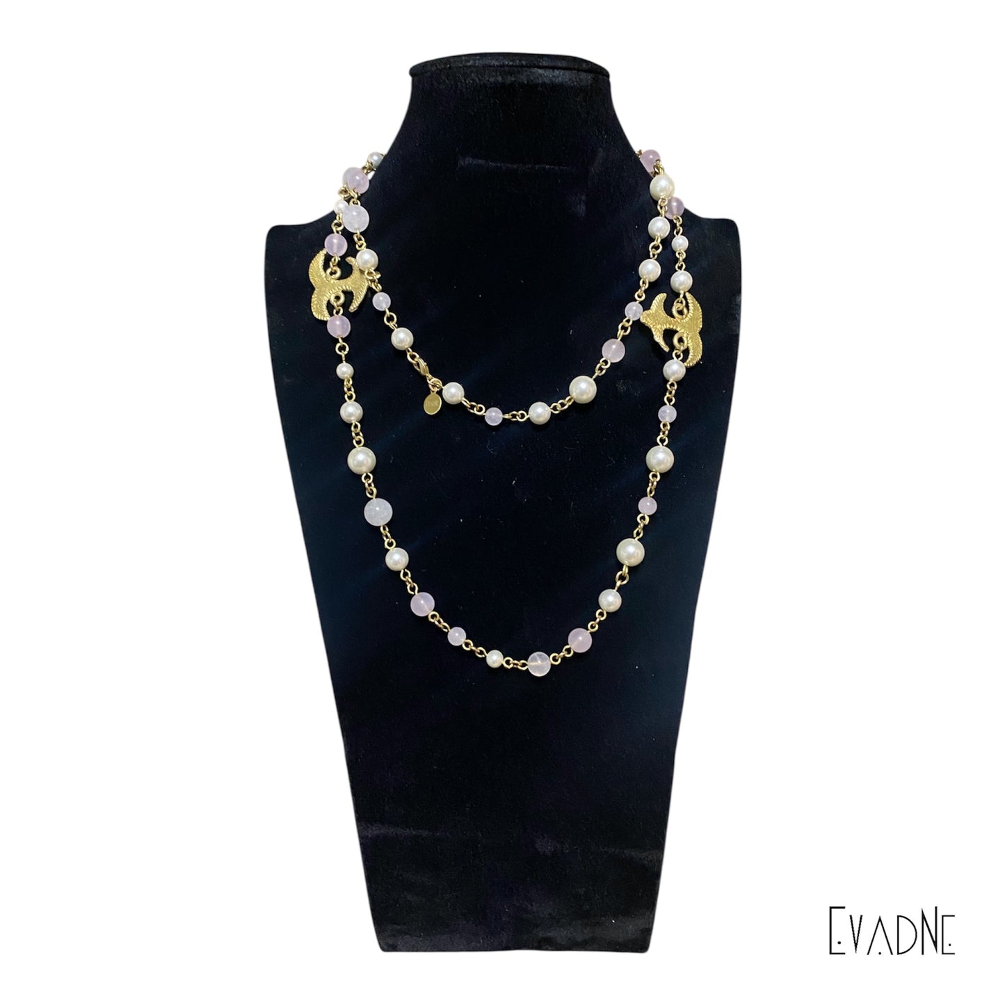 42-inch pearl and rose quartz necklace with brass Adinkra charm worn long across the chest.