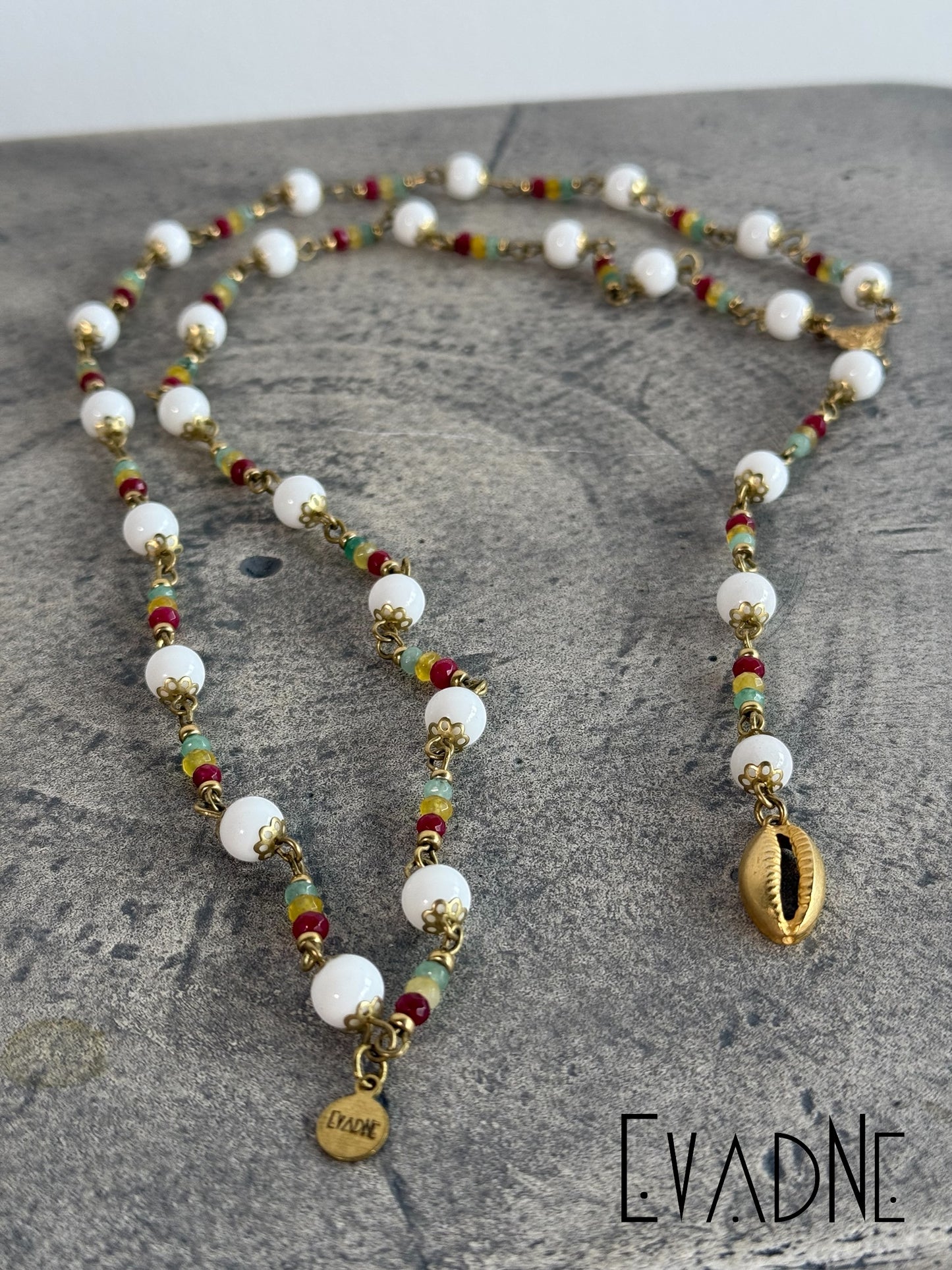Rasta Rosary crafted with 8mm brass capped smooth white agate beads accentuated Rasta inspired jade gems and finished with brass links and cowrie shell charm.