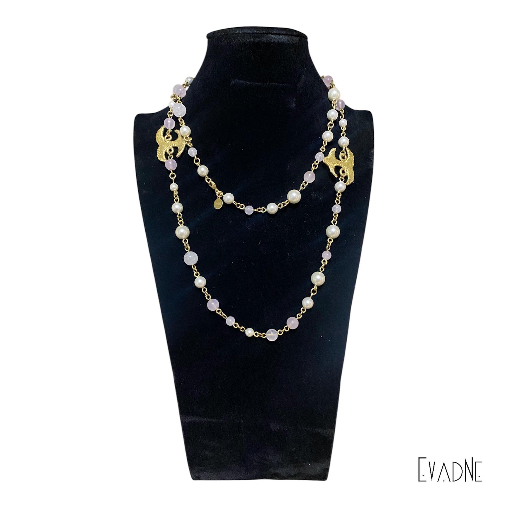 42-inch pearl and rose quartz necklace with brass Adinkra charm worn long across the chest.