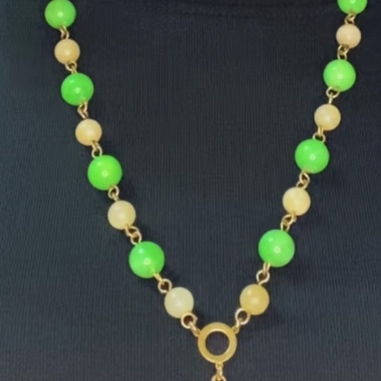 green and yellow jade rosary necklace worn with Adinkra charm