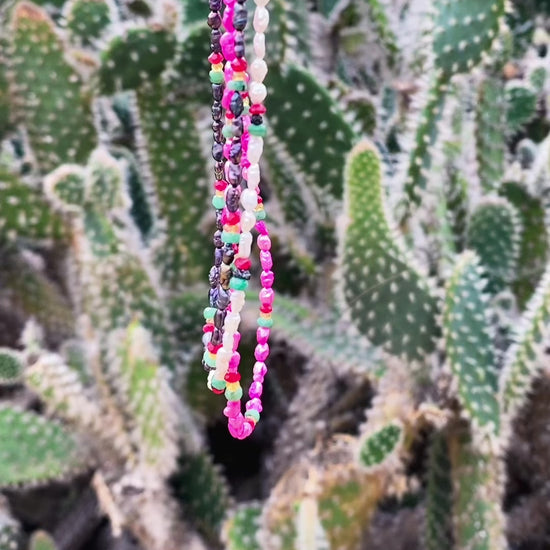 delicate pearl necklace embellished with rubies emeralds and black diamonds