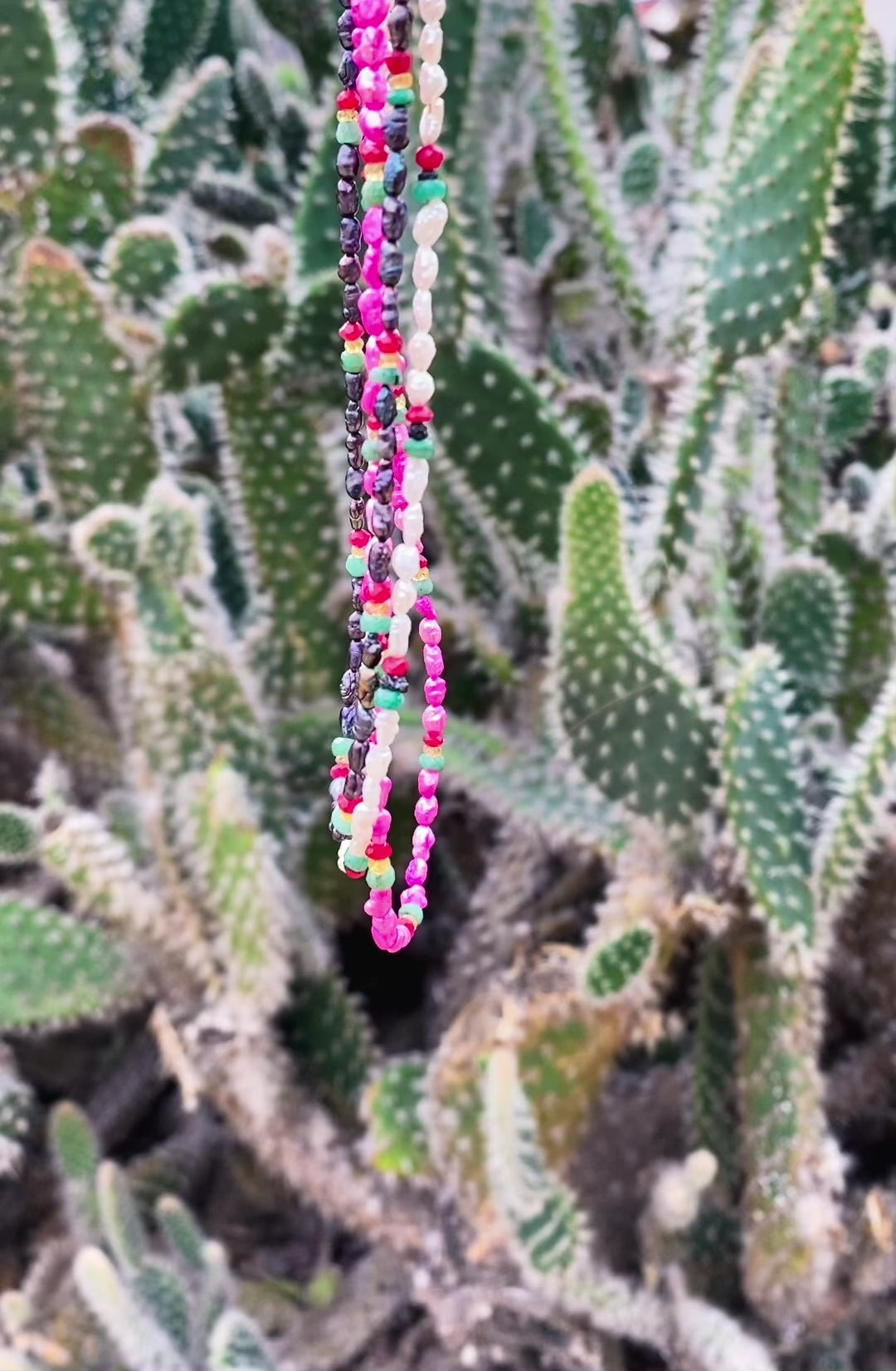 delicate pearl necklace embellished with rubies emeralds and black diamonds